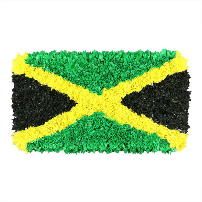 An exacting portrayal of the Jamaican flag, formed from countless small, crinkled pieces of material - recycled paper, fabric scraps, even plastic - woven into a textured tapestry set against white. The gold saltire diagonally crosses the field, bold and luminous, dividing the surface into emerald green triangles top and bottom and deep charcoal black triangles on the left and right. Each piece is distinct, its small, irregular surface catching light and shadow in a way that suggests gentle wind or a festival crowd, a tangible sign of handiwork and patience. The effect is three-dimensional and tactile, like a sculpture you could almost touch, with a handcrafted warmth that speaks of local pride and global connection. In Oxford, such artful tributes often accompany cultural events near Port Meadow or along the High Street, where residents celebrate diversity and history. The image radiates pride and contemplation, suitable for articles about Jamaica's heritage, diaspora communities in Oxford, or creative reuse in art. It invites viewers to linger, to notice texture, depth, and story threaded through every folded fragment.