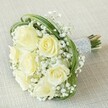 Ethereal and quietly radiant, this elegant bridesmaid's bouquet speaks of heartfelt moments and traditions cherished in Oxford's storied halls. Each creamy white rose glows from within, its petals gently unfurling in a soft gradation from tightly wrapped buds to sumptuous, fully opened blooms. Around them, airy clouds of tiny white gypsophila shimmer like morning fog drifting along the River Thames, lending the bouquet both texture and a sense of lightness. Sweeping arcs of slender green bear grass enclose the composition in delicate, modern lines, enhancing its grace and drawing the eye inward toward the blooms' pure, tranquil beauty. The stems are meticulously gathered and enclosed in a silvery, satin ribbon-smooth to the touch, adorned with parallel rows of petite, gleaming pearls that offer a tactile luxury reminiscent of Oxford's refined tastes. With an aroma both fresh and subtly sweet, the bouquet evokes the atmosphere of a joyful gathering beneath the spires or a private moment in a tranquil Oxford garden. Designed for lasting impact, this bouquet by Flowers Oxford is a token of steadfast friendship, hope, and new beginnings-perfect for any wedding or celebration across the city's vibrant neighbourhoods.