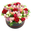 A sophisticated black round hat box, edged at the base with a slim red trim, cradles a lush, dome-shaped bouquet of roses, photographed cleanly against a pure white backdrop that intensifies the colours. The roses are arranged in a tight, continuous mound, so that from above it looks like a living tapestry of petals. Deep red roses provide a romantic core, while airy blush tones, bright fuchsia, and pale pinks weave outwards, mingling with cream and white roses that catch the light delicately. Warmer peach and coral blossoms appear like sunlit highlights, and touches of lavender and mauve thread through the design, adding depth and a hint of modern elegance. Larger, open blooms sit side by side with clusters of spray roses, whose smaller buds and half-open flowers give the arrangement a gentle rhythm, as though it were breathing. Small, fresh green leaves emerge between the petals at irregular intervals, their crisp edges and bright colour echoing the greenery you might see along the paths by the Oxford Canal, bringing a sense of life and contrast. The hat box has a matte, refined finish, grounding the design with a contemporary feel that would suit a chic apartment near Cowley Road just as easily as a classic home near the university colleges. Soft, even lighting ensures no harsh shadows, revealing the velvety texture of each petal and the smooth curve of the overall shape. This floral hat box evokes celebration and intimacy, ideal for romantic occasions, milestone birthdays, or a same-day rose delivery in Oxford when you want a gift that feels both indulgent and thoughtfully composed.
