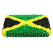 A beautifully composed floral tribute takes the form of the Jamaican flag, presented as a thick, rectangular panel that looks both solid and softly inviting, as though covered with a bed of tiny blossoms. Crafted with the kind of care often reserved for important family farewells around Oxford, the design uses thousands of small, crinkled petals and flower heads to create a richly tactile surface. A bright golden yellow diagonal cross slices confidently from corner to corner, its lines sharply defined and slightly raised with layers of compact blooms that shimmer gently under even lighting. This bold saltire separates four triangular blocks of colour: at the top and bottom, an expanse of vivid green flowers suggests freshness and renewal, reminiscent of the leafy paths around Port Meadow after spring rain. On either side, the triangles are made from densely packed black petals, smooth and velvety, bringing a sense of stillness and respect. The contrast between the lively green, radiant yellow, and solemn black is heightened by a pure white background, allowing each shade and texture to stand out clearly. Subtle shadows at the edges remind you that the piece has real depth, more like a handcrafted art installation than a flat flag. One can imagine the soft rustle of petals as it is carried gently into a service at a local Oxford chapel. This arrangement honours Jamaican identity while offering comfort to loved ones, a meaningful choice for families wishing to reflect both cultural roots and personal memories in their final tribute.