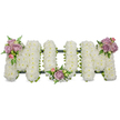 A deeply reverent funeral tribute spells the word MOM in three substantial, three-dimensional letters formed entirely from tightly packed, snowy white spray chrysanthemums that give each letter a soft, cloud-like surface. The luminous white petals read as purity and calm; under soft studio lighting their clean contours cast gentle shadows that accentuate the rounded edges and the careful craftsmanship. The left-hand M wears a small cluster of pale lavender and blush-pink roses at its upper outer curve, the velvety petals opening to reveal subtle scent notes that would be faintly floral and sweet if one stood close. The central O is cradled by a similar, slightly smaller grouping of lilac roses and pink buds at its base, while the right-hand M mirrors the left with a matching spray of pastel blooms and fresh green leaves. Slender fern fronds and lighter green foliage slip between the white chrysanthemums, providing contrast, depth and a living texture that keeps the composition feeling natural rather than rigid. A dark green structural base-either ribbon-wrapped foam or moss-covered framework-peeks through along the lower edge, visually anchoring the letters and ensuring they read as a unified memorial. This arrangement conveys a hush of respectful remembrance, appropriate for a chapel, wake or graveside service in and around Oxford. As an experienced local florist, I imagine it placed near a family photograph or on a chapel pew at St Mary's or a crematorium service, where the soft pastels and pristine whites offer comfort and quiet dignity to grieving loved ones. The overall impression is one of serene love, a bespoke tribute meant to honour a mother with grace and enduring tenderness.