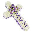 A tender, cross-shaped funeral tribute crafted from a dense carpet of pristine white chrysanthemum heads, each petal layered to create a soft, pillowy surface that reads as purity and calm against a clean white studio background. The cross is edged with a ruffled purple satin ribbon - a delicate, almost fabric-like frame whose cool lilac tones echo the deeper purples within the design. Down the vertical arm the affectionate word MUM is carefully formed from small, rich purple flower heads - likely eustoma or compact spray chrysanthemums - the letters set in relief so they read clearly from a short distance. At the centre, where the arms meet, a lush cluster becomes the focal point: deep violet and lavender roses sit close and slightly unfurled, mingling with pale purple lisianthus (eustoma) and subtle sprigs of variegated foliage whose lighter margins and darker centres add a crisp, textured contrast. Tiny green berries are tucked into the mix, offering a cool, rounded punctuation to the petals. The palette of snowy white, soft lavender and somber violet feels both consoling and dignified; there is a quiet, powdery scent and the tactile density of the blooms suggests an embrace. The composition is photographed in soft, even light so every fold of ribbon and petal is visible, communicating craftsmanship and care. As a local Oxford design this style is often chosen for funeral services at churches around Christchurch Meadows or quiet chapel services near the High Street, where understated, respectful florals speak on behalf of family and friends.