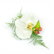 A single, pristine white Phalaenopsis orchid forms the calm, luminous heart of a compact corsage designed to be worn on a lapel or wrist. Its broad, satiny petals spread like a small, quiet moon, catching soft light and revealing a warm throat of pale yellow, gold and a whisper of tan that gives the bloom a sculpted, almost luminous depth. Surrounding the orchid, feathery asparagus fern trails outward in delicate filigree, its pale green fronds suggesting tulle or a soft veil and lending the piece an airy, romantic movement. Close to the bloom, a small cluster of lime-green chrysanthemum or similar textured filler adds a playful, verdant contrast with almost neon freshness, while glossy clusters of reddish-pink hypericum berries punctuate the design with cheerful, garden-like color. The corsage is artfully asymmetrical yet balanced, each element arranged to sit comfortably against fabric or skin, the textures alternating between waxy orchid, soft fern, and the firm, rounded berries. The white backdrop in the photograph accentuates every tactile detail and the arrangement's clean silhouette, evoking a serene, celebratory mood - a perfect accent for a wedding, prom, or formal moment when subtle elegance matters. As a florist working around Oxford, I picture this piece paired with a soft morning ceremony near Magdalen Bridge or the Botanic Garden, where the orchid's quiet radiance matches the gentle green of early leaves. The overall impression is one of refined restraint: a wearable blossom that feels both modern and timeless, carrying the scent and textures of a careful, local floral touch.