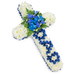 A graceful funeral cross, designed as a tribute to a beloved father, is shown resting on a bright white background that highlights every detail of the design. The cross itself is fully covered with small white spray chrysanthemums, each flower carefully placed so that the surface appears smooth and luxuriously full, like a soft floral tapestry. This immaculate white base symbolises peace and remembrance, and its gentle texture invites the eye to linger. Framing the entire shape is a wide band of royal blue satin ribbon, folded neatly around the edges and subtly pleated along each curve, creating a strong contrast that adds depth and definition. At the centre of the cross, a cluster of vivid blue blooms stands out: rounded blue carnations and possibly elegant stems of blue delphinium or orchid, all nestled among glossy dark green foliage and lacy ferns, bringing a sense of life and movement to the arrangement. On the vertical arm, the word DAD is delicately formed from the same royal blue ribbon, each letter crafted by looping and twisting the fabric so it sits proudly on the white chrysanthemum cushion. The even, studio-style lighting ensures that the blues appear rich and saturated, while the whites remain clean and bright. This image captures the kind of personalised sympathy tribute that might be created by an Oxford florist for a funeral at a local church in Summertown, Cowley, or near the city centre, conveying deep love, respect, and a final message of farewell.